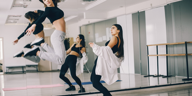 Dwie kobiety na sali tanecznej w trakcie tańca Salsa Solo